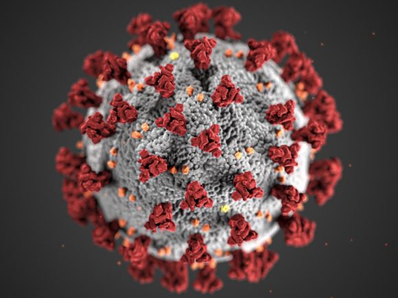 Simulation of the COVID-19 virus on a dark grey background with glowing red dots surrounding it