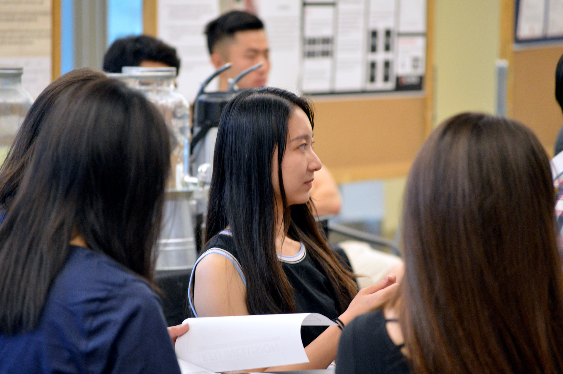 Photograph of students sitting at a table during a SPIN program ceremony
