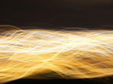 Abstract yellow, orange, and white action lines from left to right on a black background