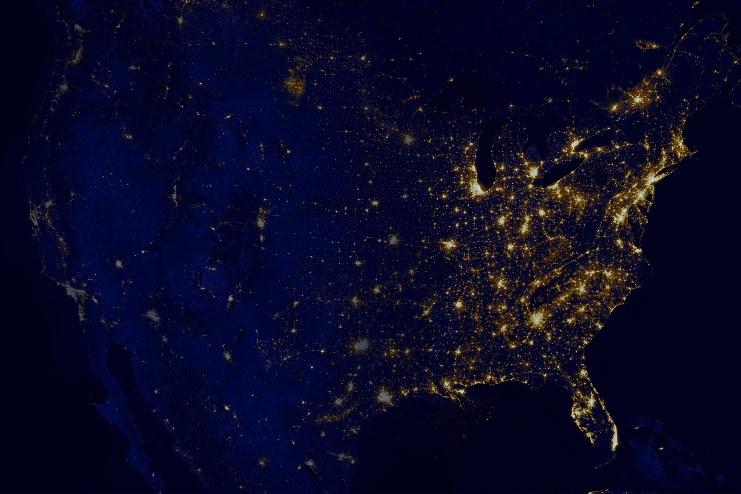 Satellite Image of the US at night. Larger cities have brighter light emissions, and the east coast is more illuminated than the west coast.