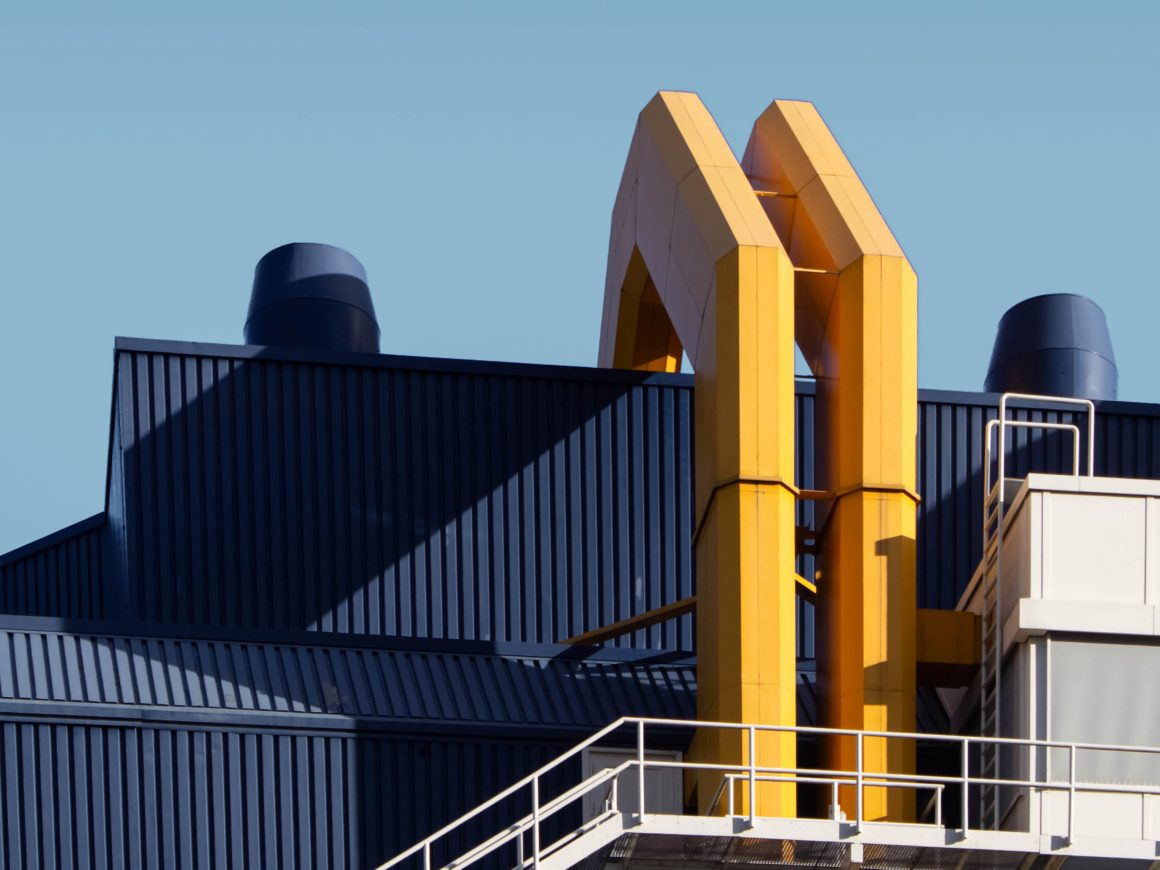 Architectural photograph of an industrial building with yellow pipes and stair railing