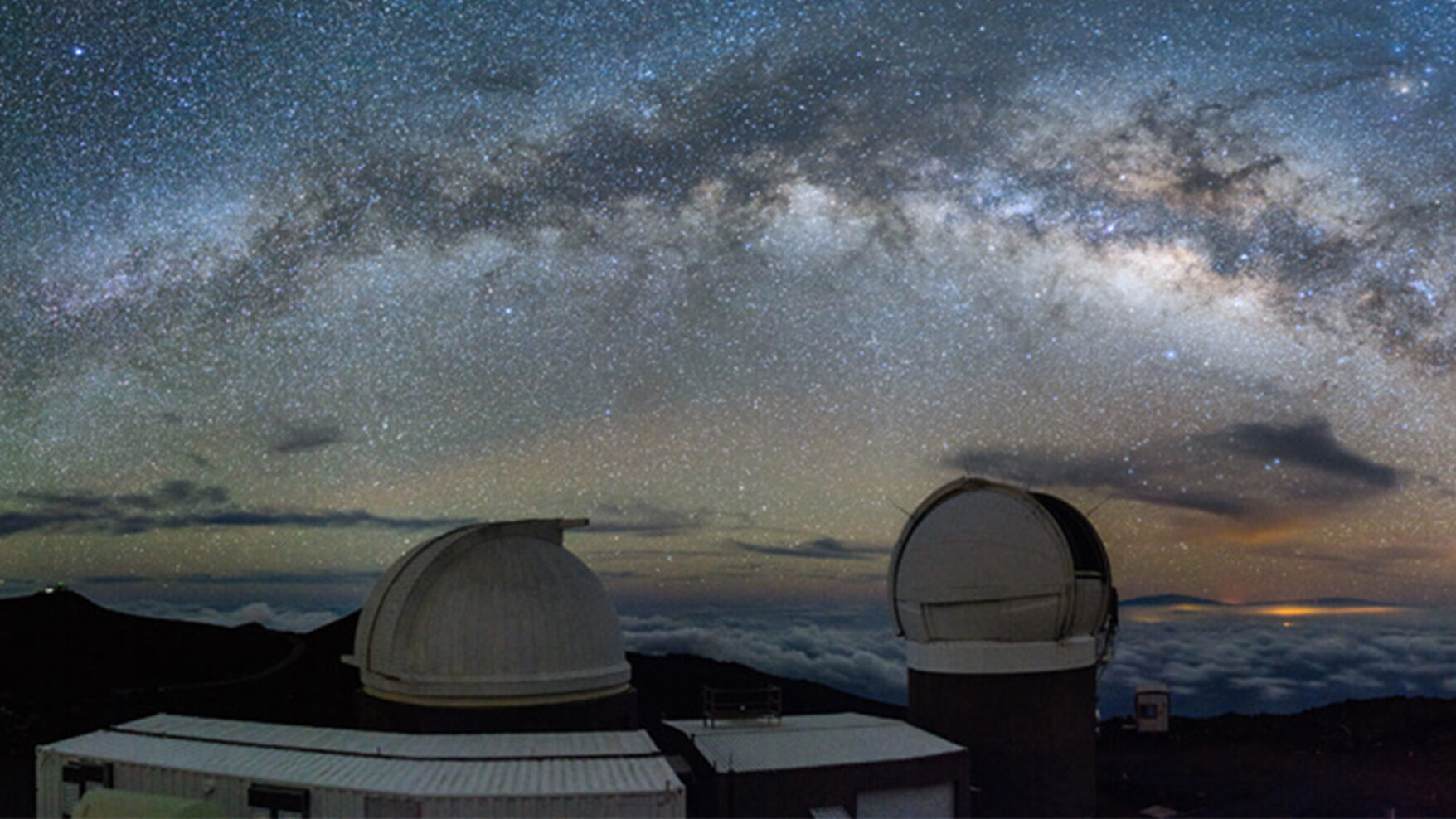 A starry night sky with the Pan-STARRS telescopes.