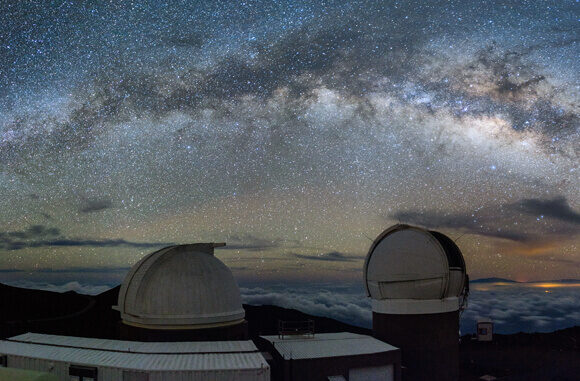 A starry night sky with the Pan-STARRS telescopes.