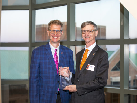 A photo of NCSA Director Bill Gropp standing with William Bernhard holding a faculty leadership award.