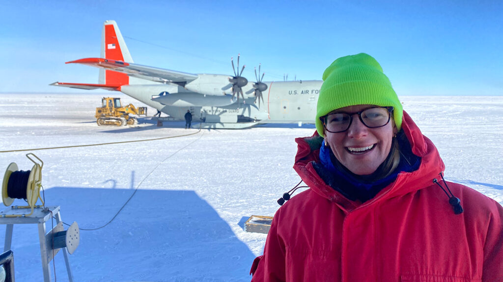An image of researcher Melanie Archipley in front of an airplane.
