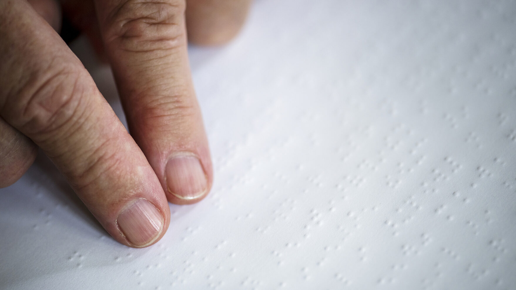 photo of someone reading braille with their fingers