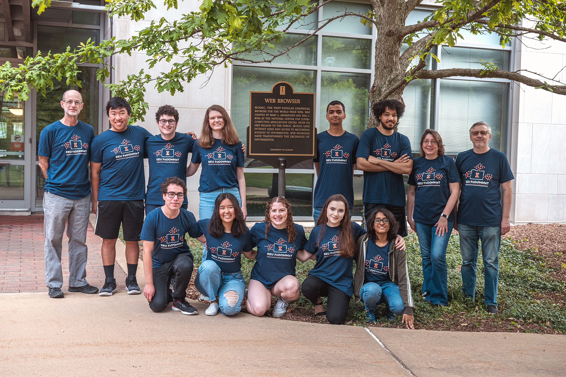 REU FoDOMMaT students, mentors and program administrators standing in front of NCSA’s plaque celebrating the creation of Mosaic. Photo credit: Priyam Mazumdar, REU graduate research mentor