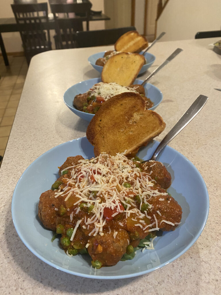 Plated homemade spinach fettuccine and meatballs