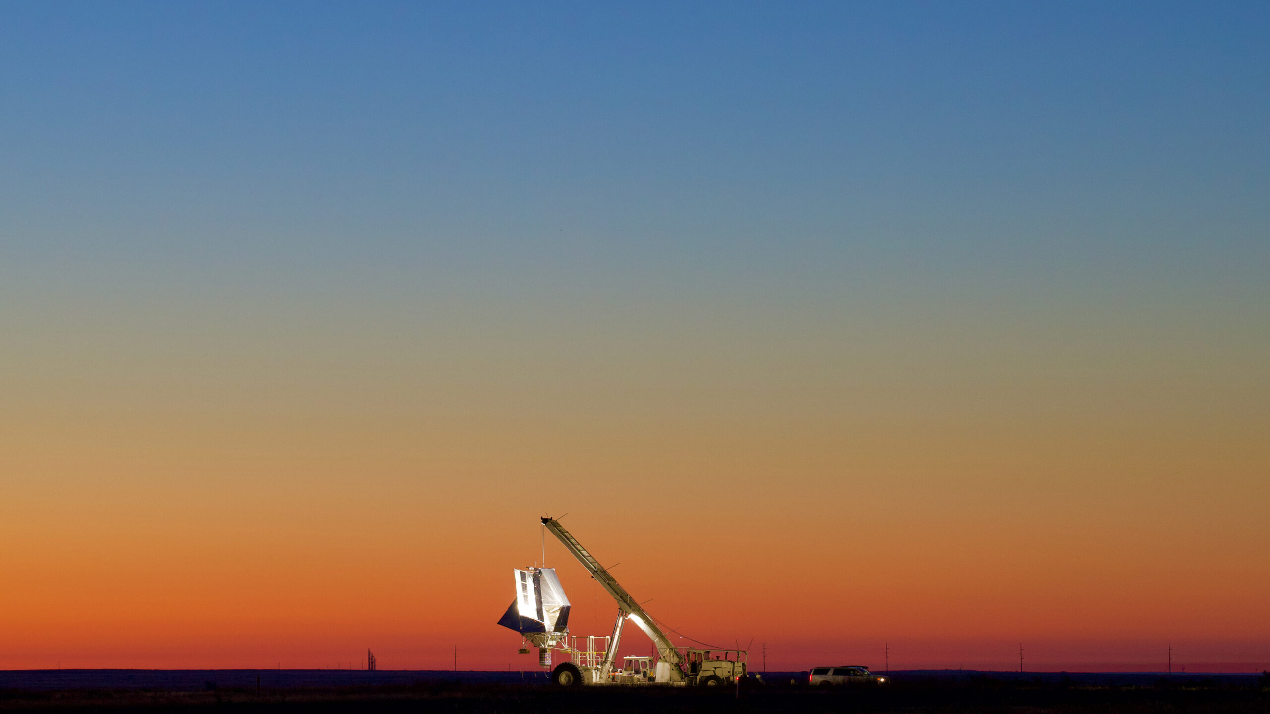 A huge scientific balloon is put into place before launch during sunset.