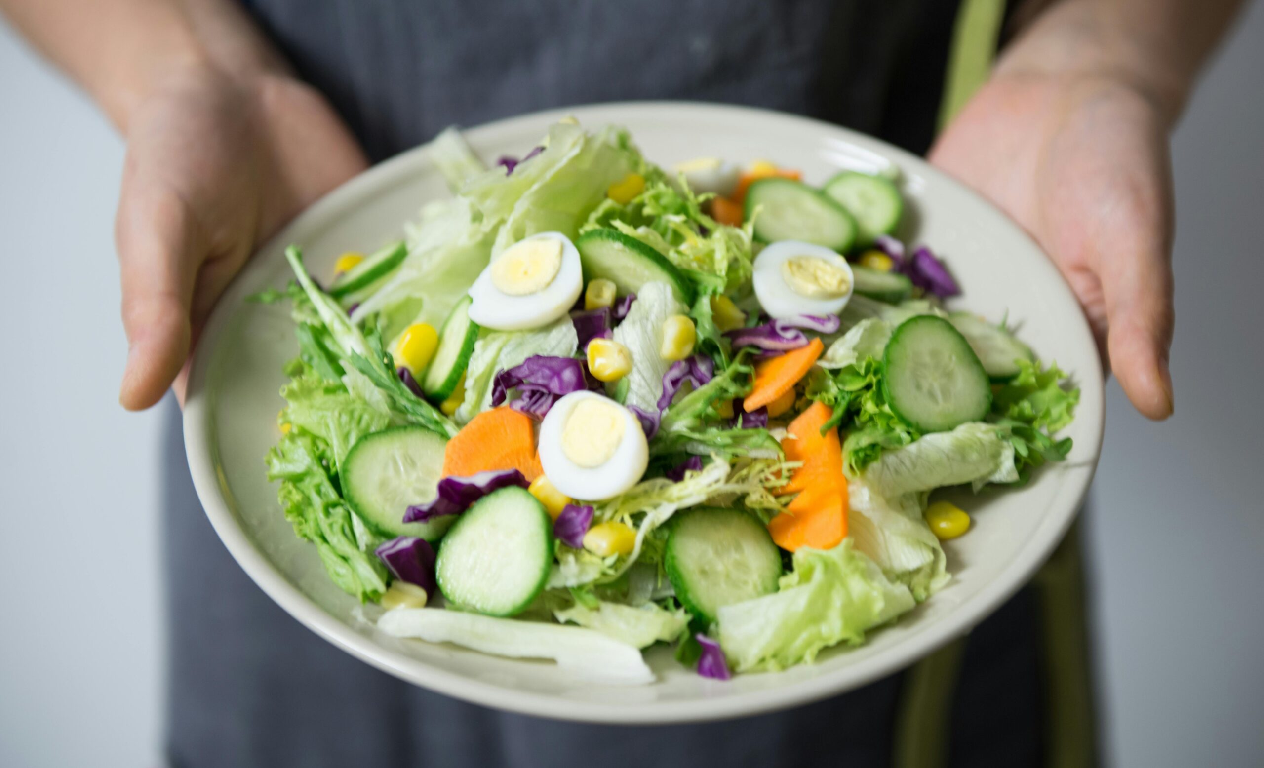 A picture of someone holding a plate of salad.