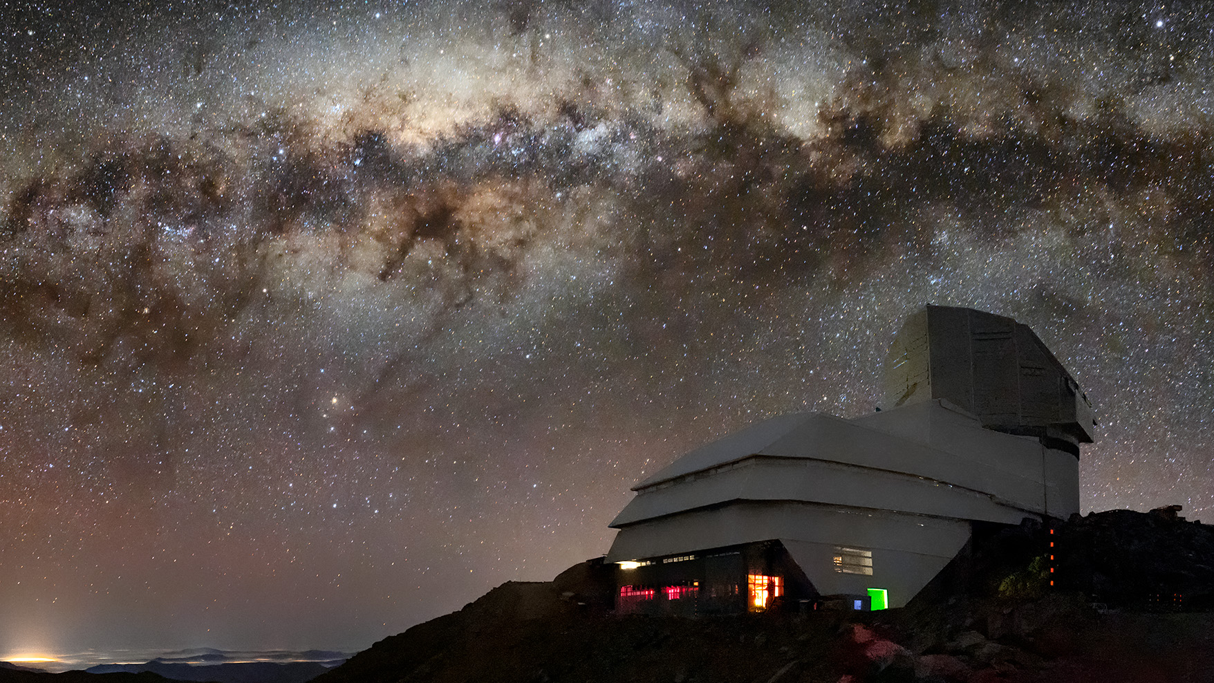 A picture from the ground of the Rubin Observatory at night with the Milky Way overhead.