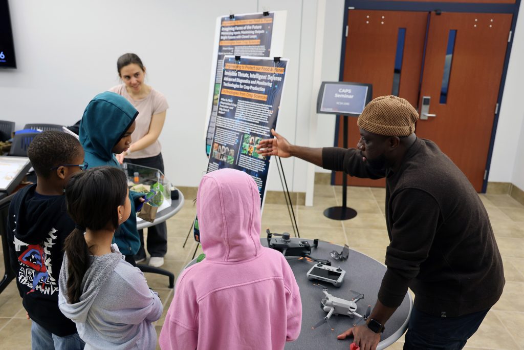 A researcher explains their poster details.