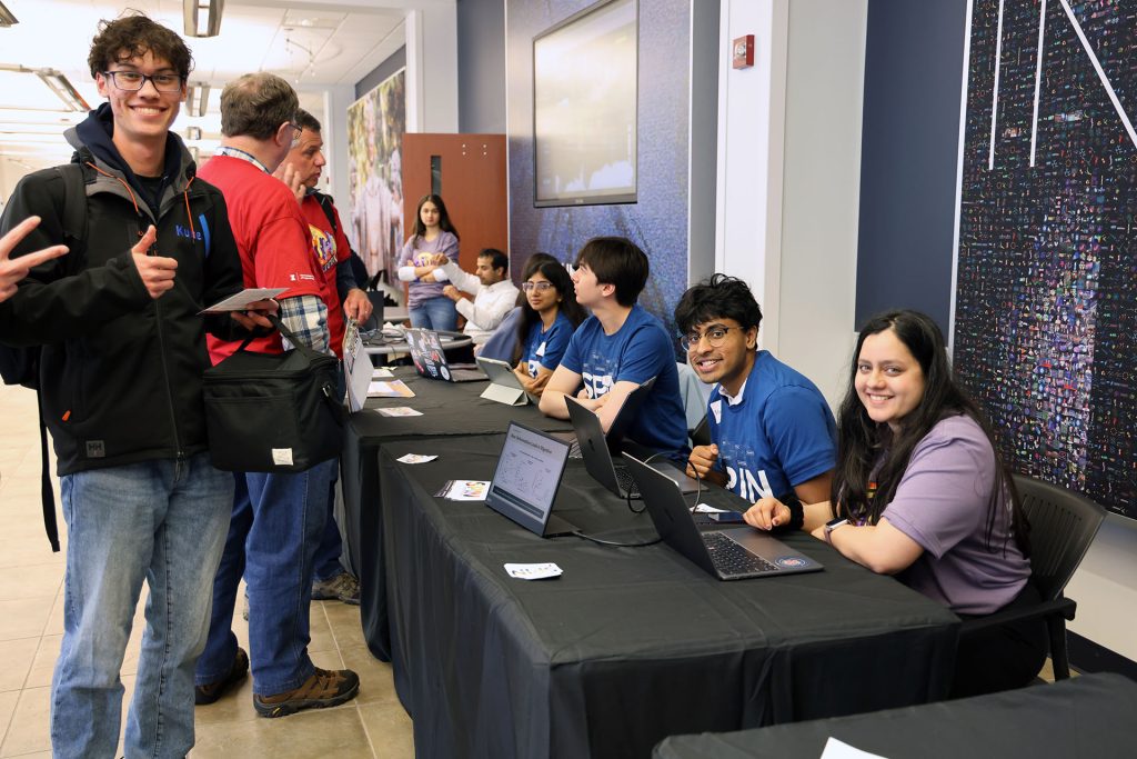 Students wait at a table for EOH visitors.