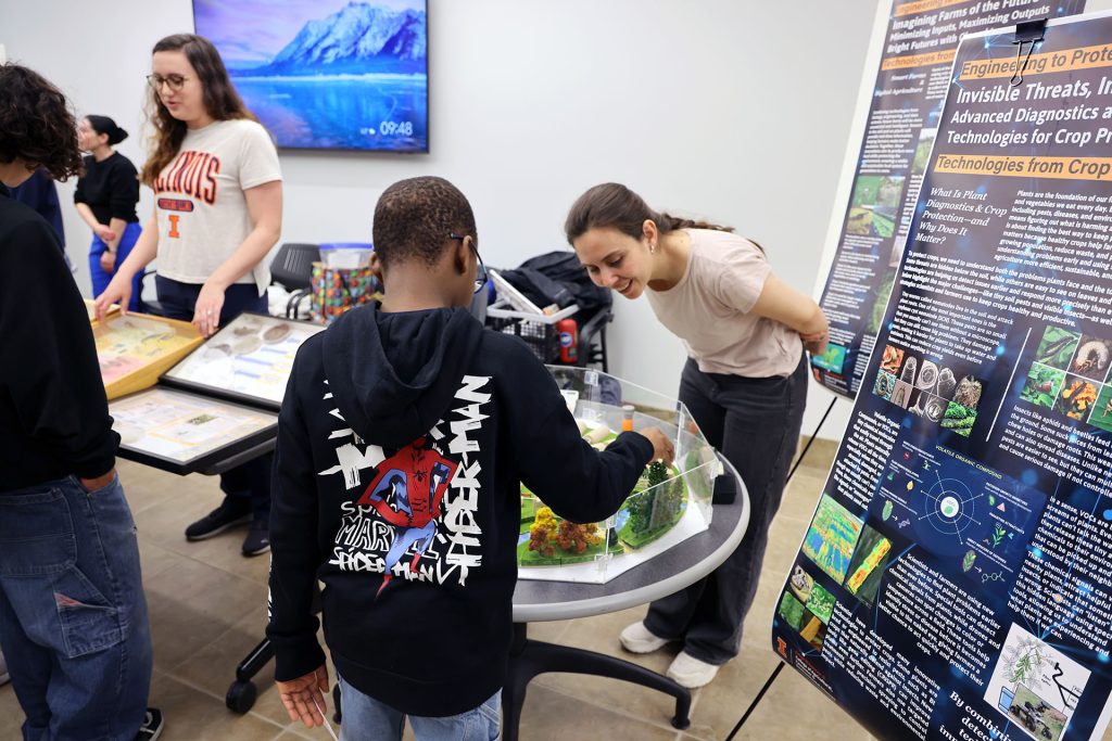 A booth attendee explains a research project to a visitor.