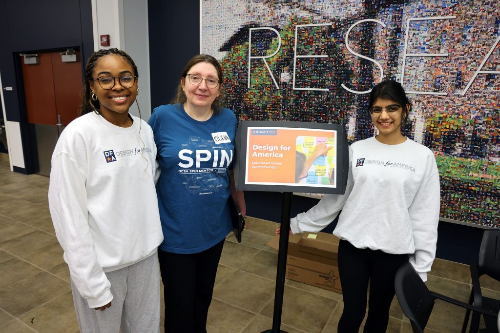 Several booth workers pose and smile.