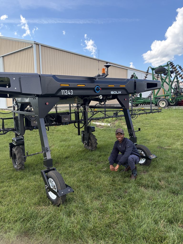 CDA REU participant Scedric Jackson with autonomous farm equipment.